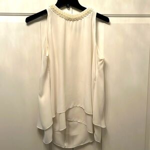 White sleeveless top with pearl necklace detail
